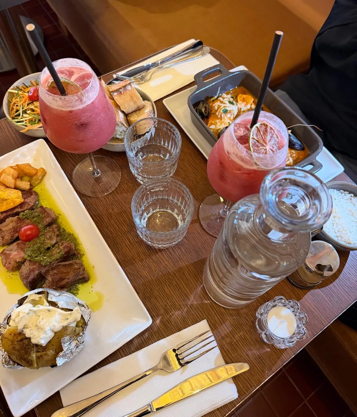 Table dressée au MAMBA : pièce de bœuf chimichurri, marmite du pêcheur et cocktails maison